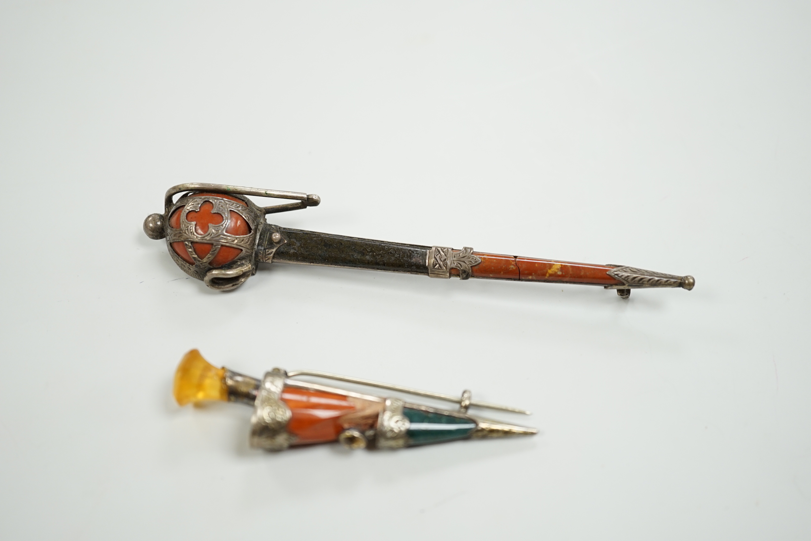 Two early 20th century white metal and Scottish hardstones set dagger or sword brooches, largest 11.6cm.